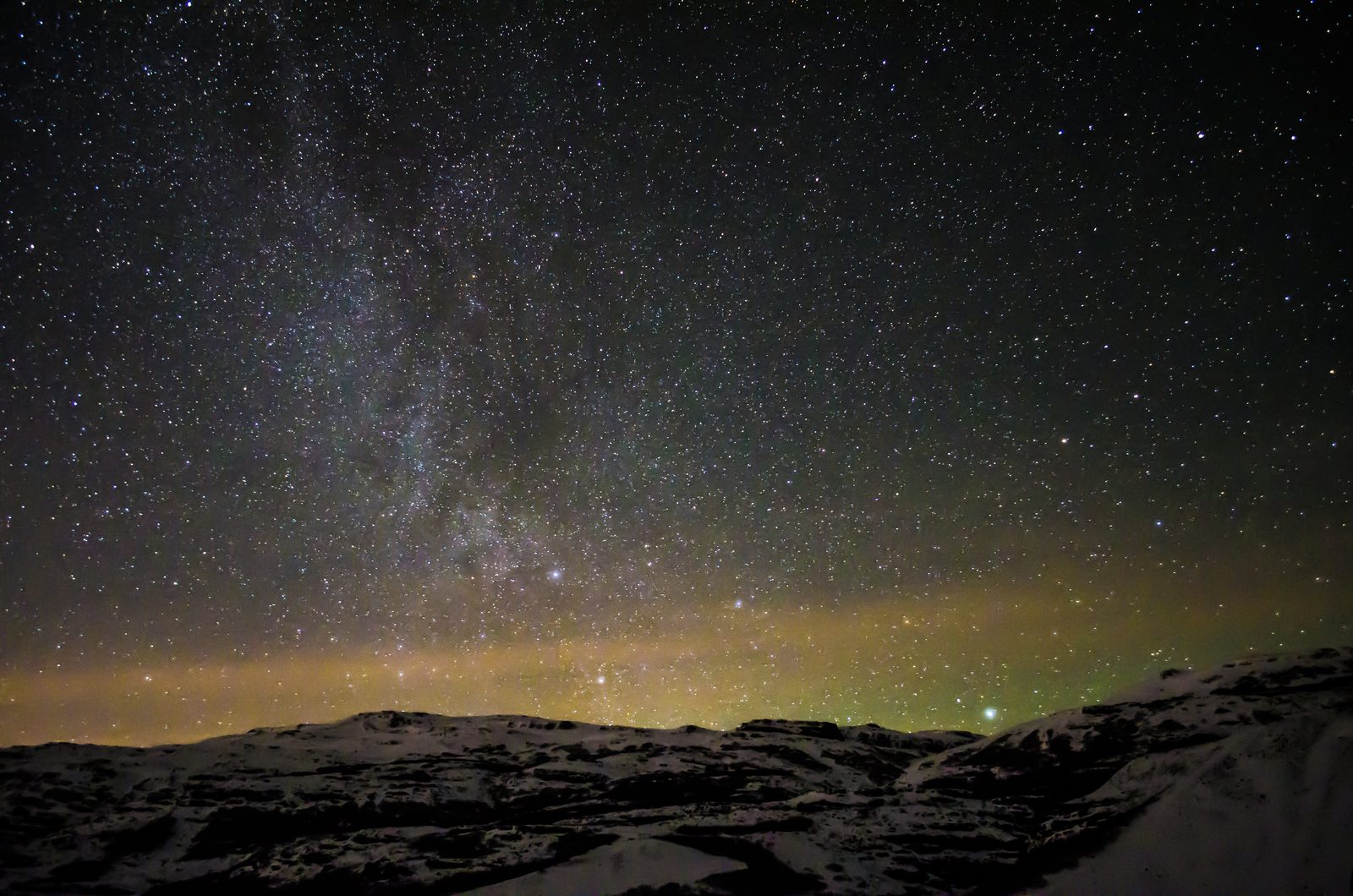 Sternenhimmel mit Milchstrasse über verschneiten Bergen in Island